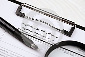 N-400 Application for Naturalization blank form on A4 tablet lies on office table with pen and magnifying glass