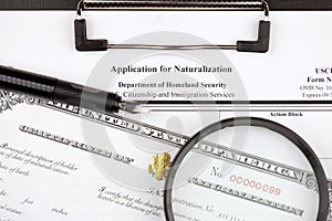 N-400 Application for Naturalization and Certificate of naturalization on A4 tablet lies on office table with pen and