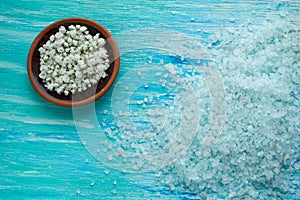 N sea salt with flowers on wooden table