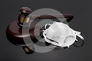 N95 face mask and gavel isolated on black background