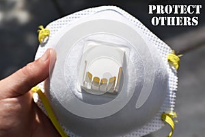 N95 Respirator In Hand With Protect Friends & Familty Close Up