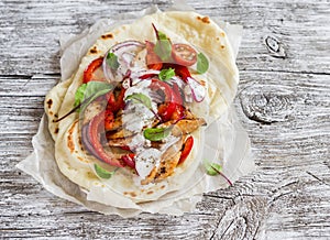 Naan bread and chicken vegetables stir fry in light wood rustic background.