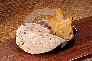 Naan bread and samosa for indian curry in plate on wood table, Indian traditional cuisine