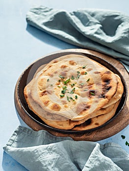 naan flatbread on blue, copy space, vertical photo