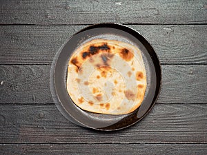 Naan flatbread on dark wood, copy space, top view photo