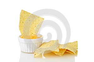 Nacho chip dipped in bowl of cheese