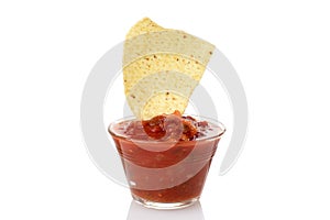 Nacho chip dipped in bowl of salsa