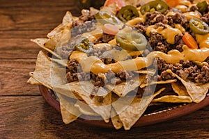 Nacho chips corn garnished with ground beef, melted cheese, jalapeÃÂ±o peppers, mexican spicy food in mexico