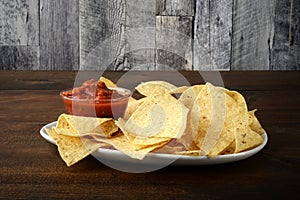 Nacho chips with salsa on white plate