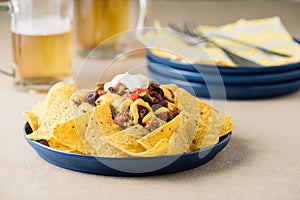 Nachos with beef, jalapeno peppers, olives, tomato, beans, cheese and sour cream