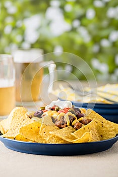 Nachos with beef, jalapeno peppers, olives, tomato, beans, cheese and sour cream