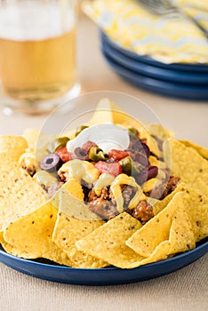 Nachos with beef, jalapeno peppers, olives, tomato, beans, cheese and sour cream