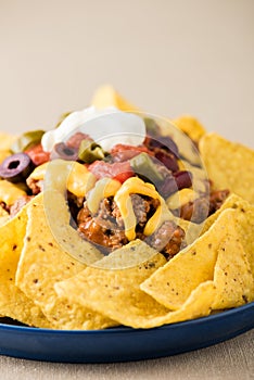 Nachos with beef, jalapeno peppers, olives, tomato, beans, cheese and sour cream