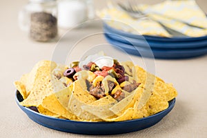 Nachos with beef, jalapeno peppers, olives, tomato, beans, cheese and sour cream