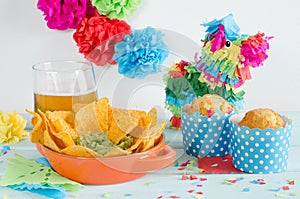 Nachos with guacamole and beer accompanied by muffins