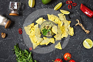 Nachos. Tortilla Chips with Guacamole on black stone background