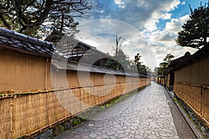 Nagamashi district or samurai district street with dramatic sky showing the earthen walls covered with straw mats, Kanazawa, Japan photo