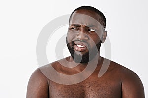 Nah bad idea. Portrait of displeased good-looking mature dark-skinned naked male with beard, squinting while staring