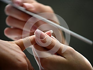 Nail beautician polishing nails photo