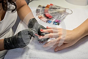 Nail care in a beauty salon manicurist hand painting client's nails.