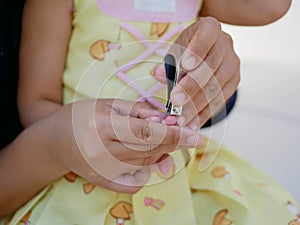 A nail clippers in mother`s hand trimming her baby girl`s fingernails - cutting baby`s nails