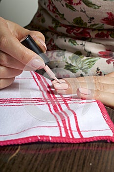 Nail coating with gel-varnish. A woman is applying a nail polish on her nails.