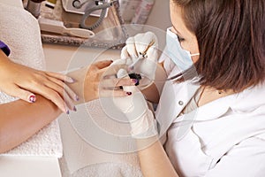 Nail designer finishing acrylic fingernails