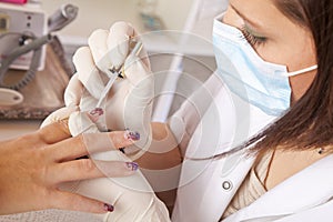 Nail designer finishing acrylic fingernails