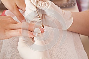 Nail designer working on acrylic fingernails photo