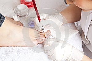 Nail designer working on acrylic toenails