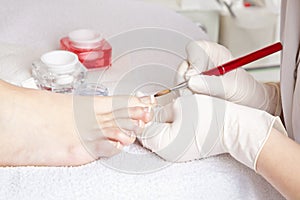 Nail designer working on acrylic toenails photo