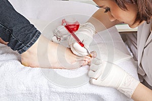 Nail designer working on acrylic toenails photo