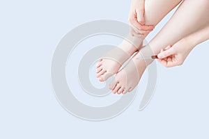Nail file in the hands of  caucasian woman. Women`s legs. Leg skin care concept