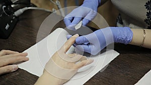 Nail filing and hand care. Woman hands receiving a manicure in beauty salon.