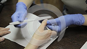 Nail filing and hand care. Woman hands receiving a manicure in beauty salon.