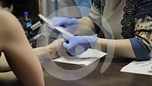 Nail filing and hand care. Woman hands receiving a manicure in beauty salon.