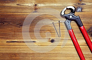 Nail and nail puller on a wood board photo