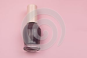 Nail polish bottle isolated on pink background. Top view with copy space