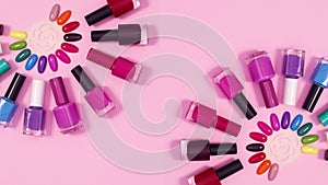 Nail polish bottles appear around colors samples on pink background. Stop motion flat lay