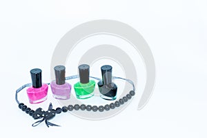 Nail polish bottles of different colors and a beautiful necklace