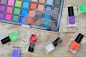 Nail polish bottles of different colors on white wooden table.