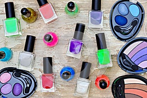 Nail polish bottles of different colors on white wooden table.