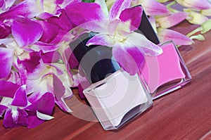 Nail polish bottles and pink orchid flowers