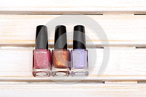 Nail polish bottles on white wooden background