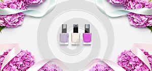 Nail polish, Decorative cosmetics. Set of different varnishes for manicure nails on light background with flowers of pink