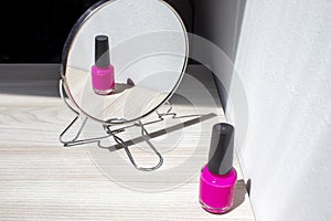 Nail Polish in Mirror Reflection. Bottle of Pink Nail Polish on a Light Background with Copy Space for Text