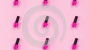 Nail polishes bottles rotate on pastel pink background. Stop motion