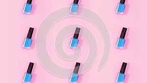 Nail polishes bottles rotate on pastel pink background. Stop motion