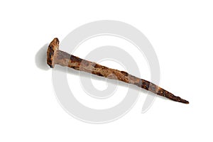 An old rusty nail lies on a white background.