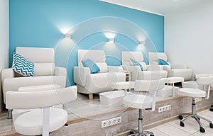 Nail salon bright interior, modern pedicure armchairs in manicure shop